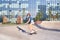 Young woman in short skirt skating on longboard outdoor in a skate park, doing the trick.