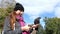 A young woman shots a dove sitting on her hand with her mobile in slo-mo