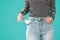 Young woman showing doesn`t has nothing in her jeans pockets on blue background