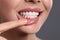 Young woman showing inflamed gums on grey background, closeup