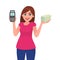 Young woman showing pos terminal or credit/debit cards swiping machine and holding bundle of cash/money/currency notes.