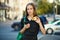 Young woman shows a credit card and holds a mobile phone in the