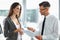 Young Woman Signing Documents at Car Dealership with Salesman