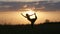 Young woman silhouette entering dancer yoga pose in front of beautiful sunset, Fruska gora, Novi Sad, Serbia.