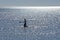 Young woman in silhouette practices stand up paddleboarding