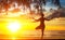 Young woman silhouette practicing yoga on beach.