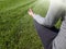 Young woman sit on grass in park and meditates in Lotus Position Padmassana, back view. Yoga, relaxation in nature