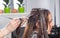 Young woman sits in a chair during process of dyeing hair and lo