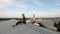 Young woman sits with laptop and listening music on headphones on the rooftop.