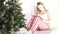 A young woman sits in the morning at the Christmas tree