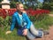 The young woman sits near the bright blossoming tulips