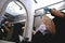 Young woman sits with phone and laptop during professional hair dyeing in a hairdressing salon