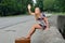 young woman sits on side of road - waving