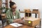 young woman sits at table, writing a return order, expressing her desire to return a product.