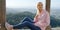 Young woman sits on the wall of Palace of Pena in Portugal - CITY OF LISBON - SINTRA. PORTUGAL - OCTOBER 15, 2019