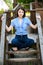 Young woman sits on wooden ladder