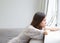 Young woman sitting alone looking out window