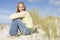 Young woman sitting amongst dunes