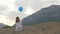 Young woman sitting on the beach with balloon