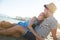 Young woman sitting on beach with boyfriend cuddling with him