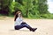 young woman sitting on a beach outdoor fashion portrait