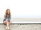 Young woman sitting at the beach thinking