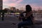 Young woman is sitting on a bench in a harbor