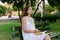 Young woman is sitting on the bench in the park and thinking about what she has read