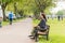 Young woman sitting on bench in summer park