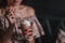 Young woman sitting in cafe holding spoon ang glass with coffee or milkshake with whipped cream