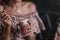 Young woman sitting in cafe holding spoon ang glass with coffee or milkshake with whipped cream