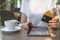 Young woman sitting in cafe and using modern tablet and credit card