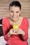 Young woman sitting on carpet and enjoying apple