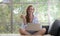 Young woman sitting on a couch using laptop computer and holding a apple looking relaxed and comfortable