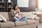 Young woman sitting on the couch and watching tv