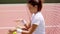 Young Woman Sitting on Court Bouncing Tennis Ball