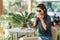 Young woman is sitting and drinking a cup of hot beverage in a elegance cafe.