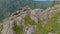 A young woman is sitting on the edge of a mountain cliff