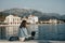 Young woman sitting on Embankment on the beach at sunset and prints in the laptop. Vacations, freelancer, lifestyle