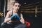 Young woman sitting on the floor after hard workout in gym.