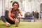 Young woman sitting in a gym tying her shoelaces