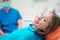 Young woman sitting on hospital clinic bed after health medical treatment - Coronavirus swab test concept - Focus on girl eye