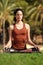 Young woman sitting in lotus position doing yoga in park