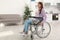 Young woman sitting in modern wheelchair