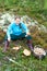 Young woman sitting on moss with basket with mushrooms