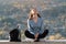 Young woman sitting in nature looking at sky and enjoying life. Front view