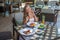 Young woman sitting in outdoor tropical restaurant