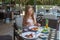 Young woman sitting in outdoor tropical restaurant