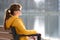 Young woman sitting on park bench relaxing on warm spring day