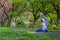 Young woman sitting in a park and stretching